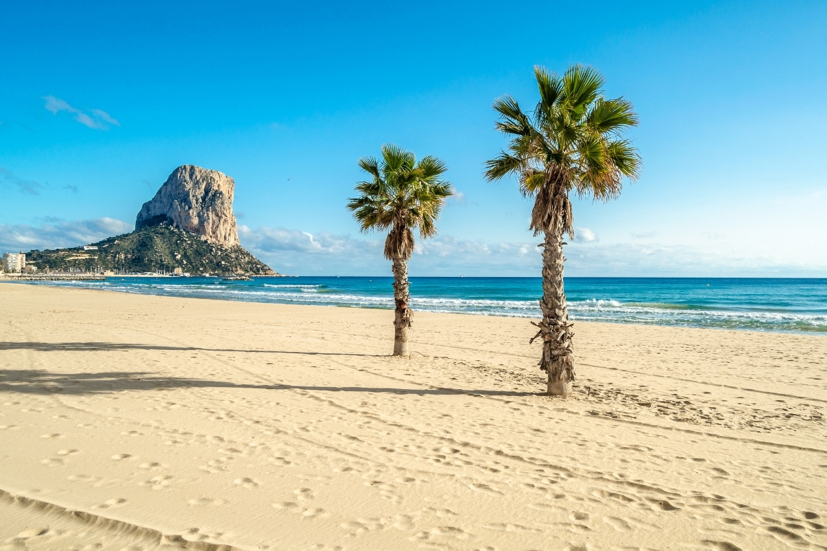 Arenal Bol Beach in Calpe with palm trees and the Peñón de Ifach in the background