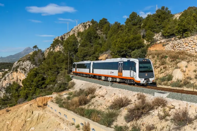 Calpe TRAM train on the coastal Line 9 route near Olla Altea, with the marina and mountains in the background