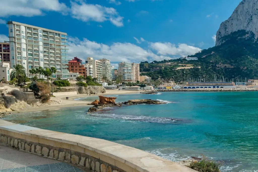 Cantal Roig Beach in Calpe with clear water and the Peñón de Ifach in the background