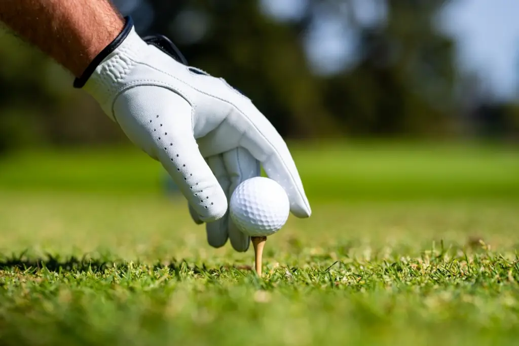 Golfer placing a golf ball on a tee at a golf course near Calpe
