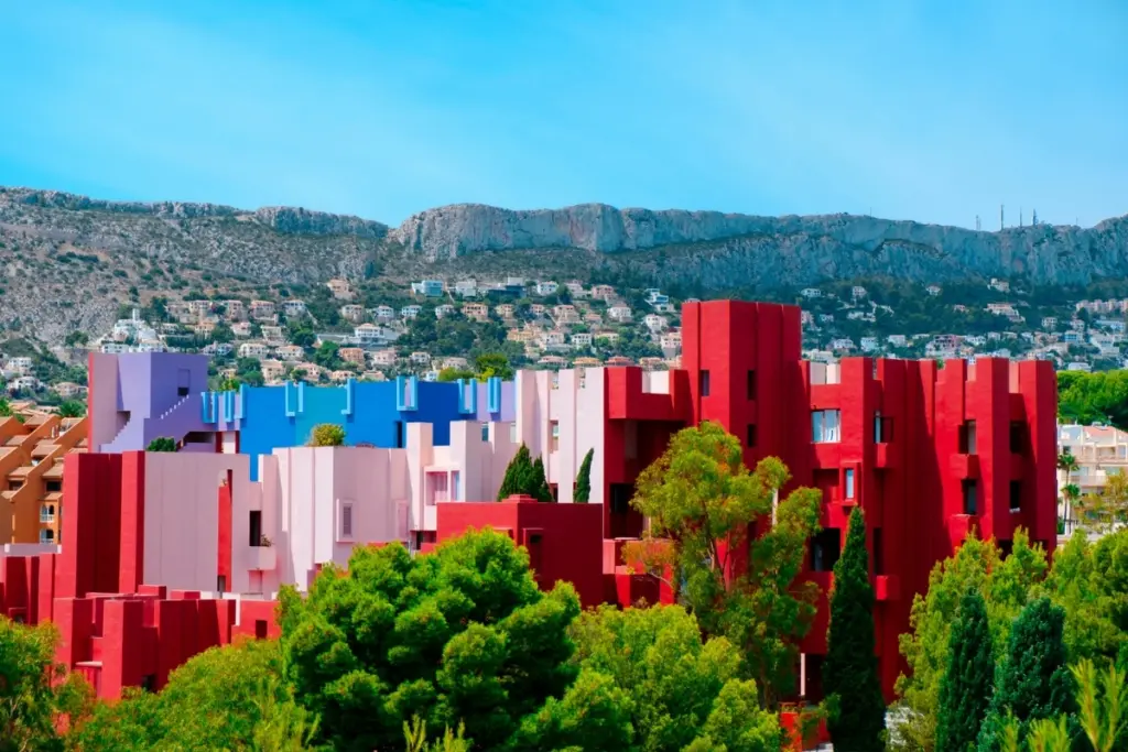 La Muralla Roja in Calpe with its red, pink and blue buildings beneath the Sierra de Oltà