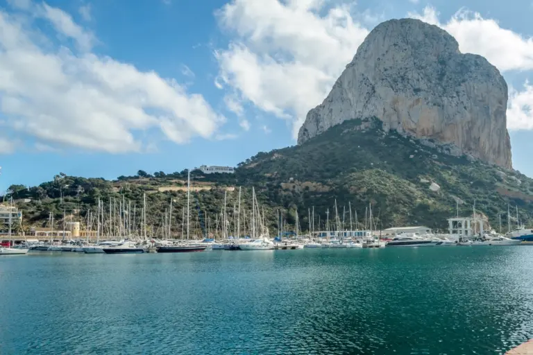 Calpe port beneath the Peñón de Ifach on a bright Mediterranean day.