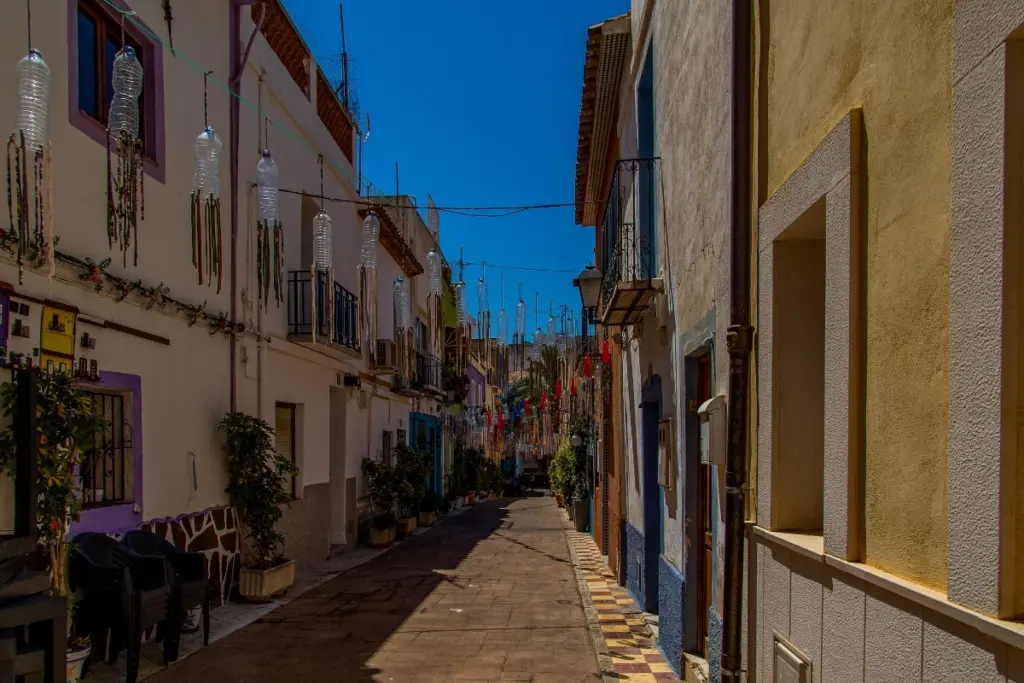 Narrow decorated street with colourful houses in Calpe Old Town.