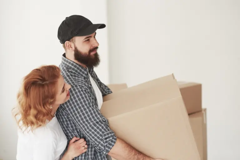 Couple carrying moving boxes into their new home, representing a move to Calpe