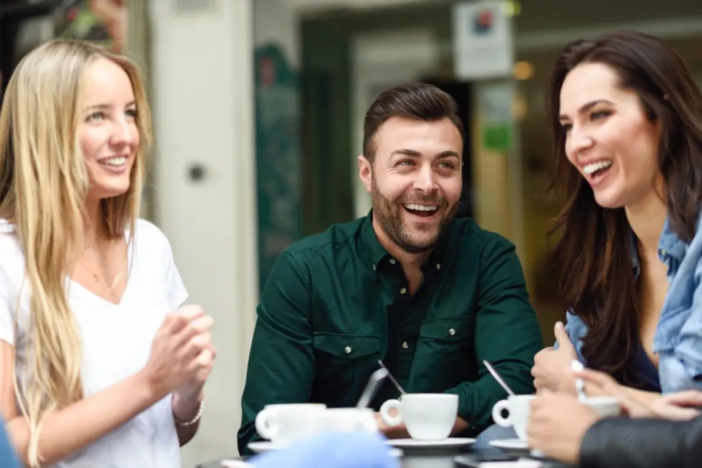 Friends talking and having coffee together at a café.